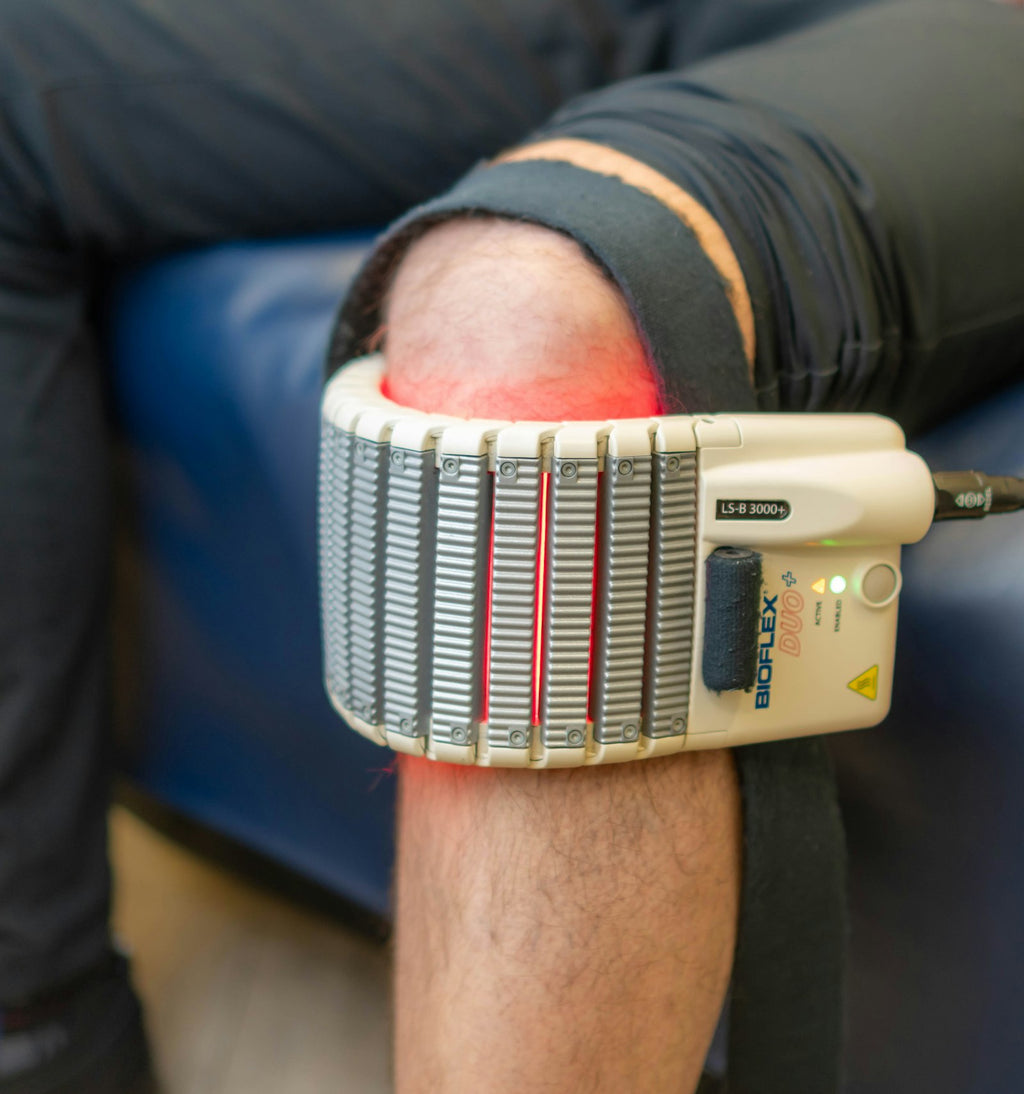 Warmte- en massagetherapie apparaat op een knie