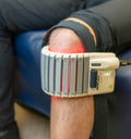 Warmte- en massagetherapie apparaat op een knie